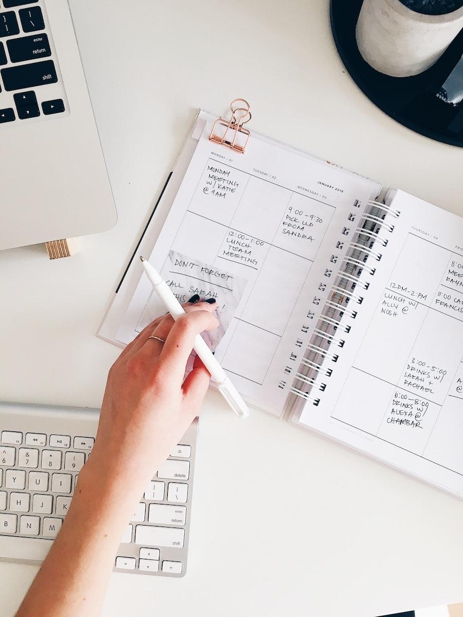 Person holding a notepad and pen
